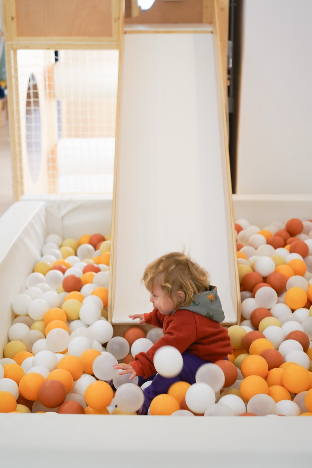 Child playing in ball pit at Tribu House play cafe in Poblenou, Barcelona
